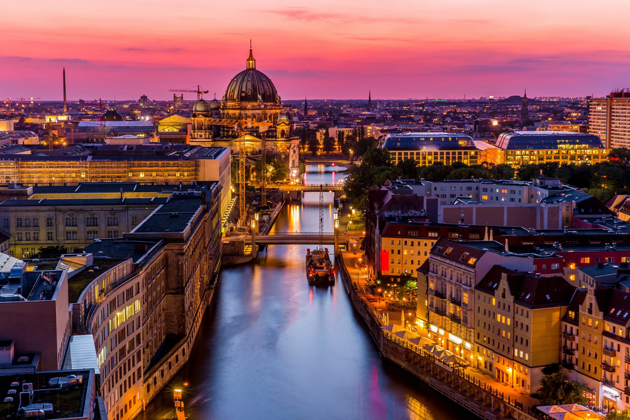 European city rooftops and illuminated church domes at sunset