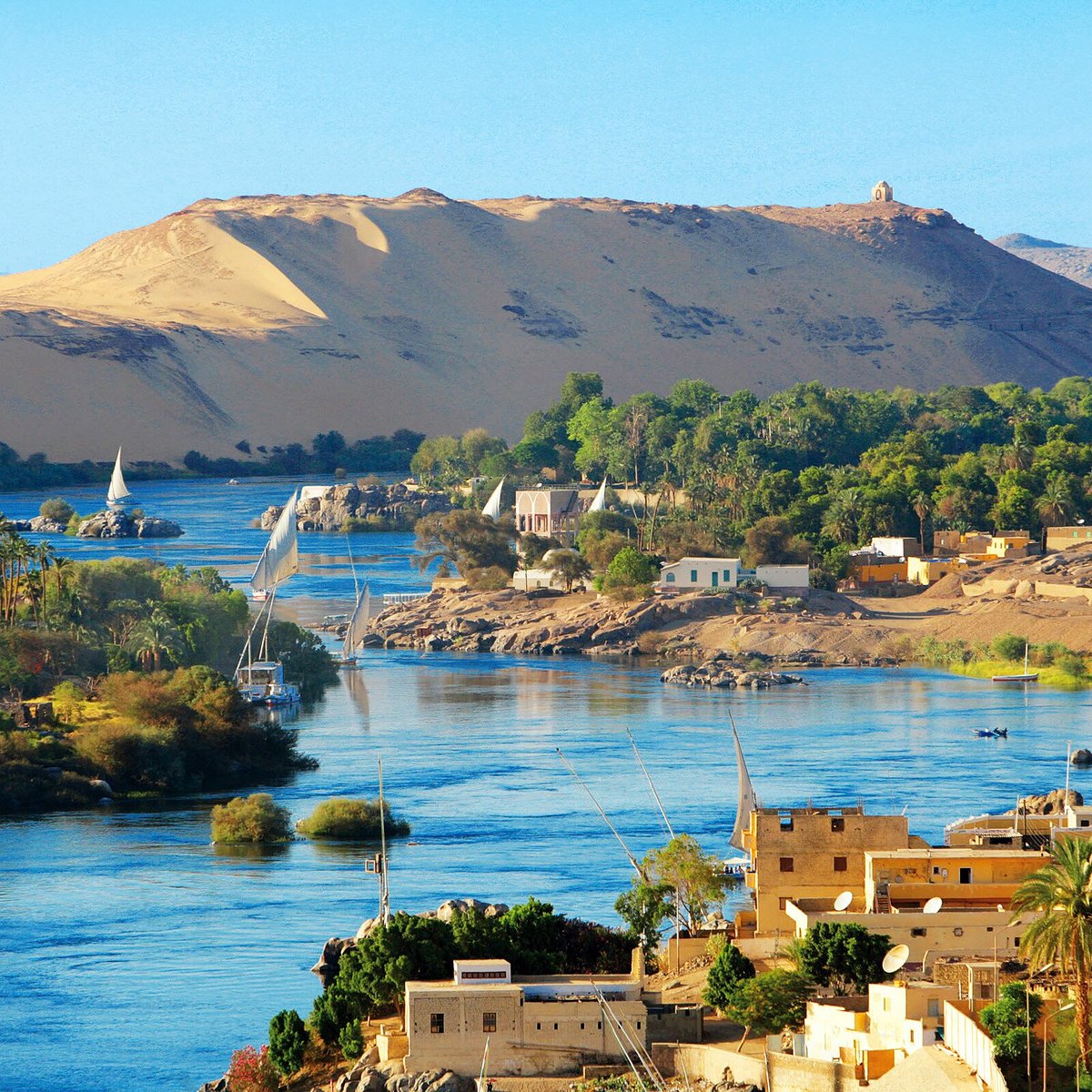 Nile River and riverside buildings beneath desert hills in Aswan