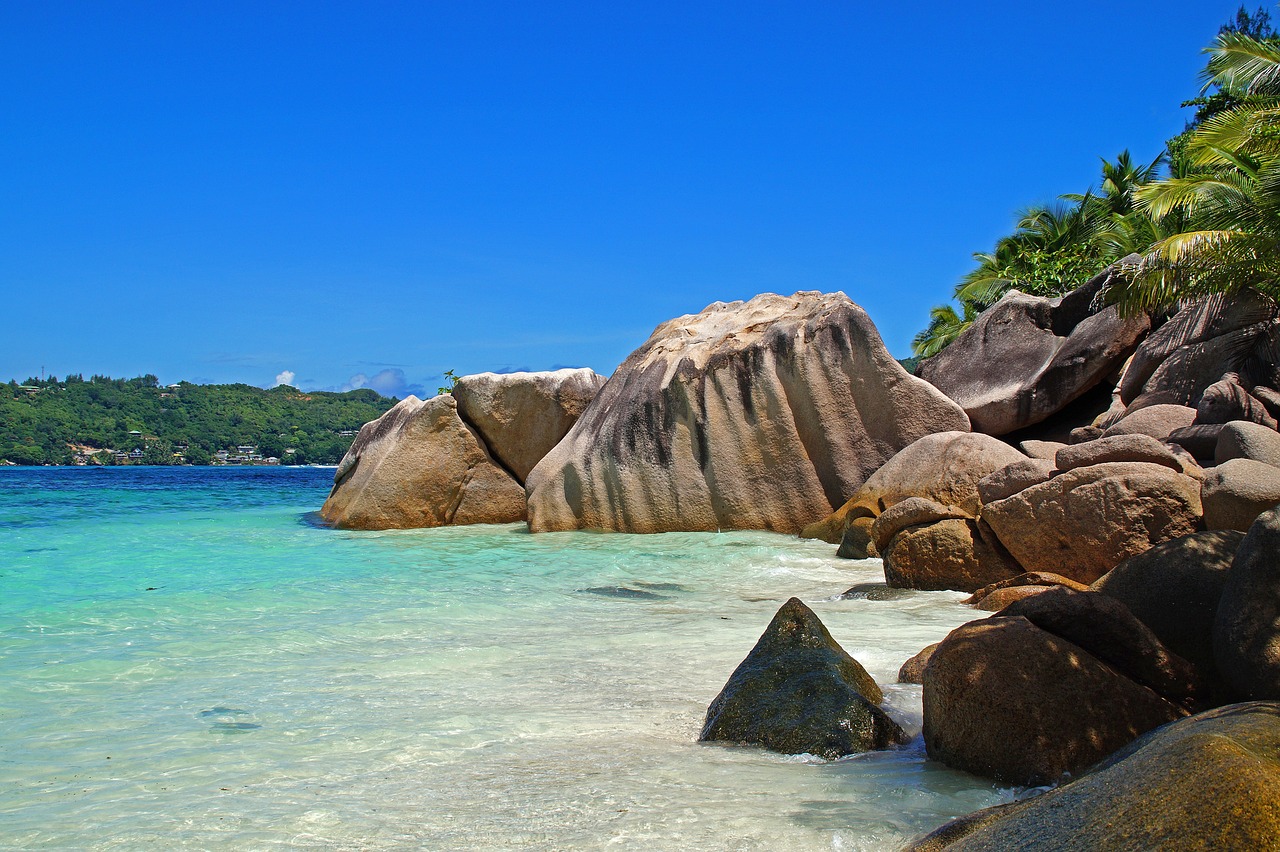 Granite boulders beside clear turquoise beach water in the Seychelles